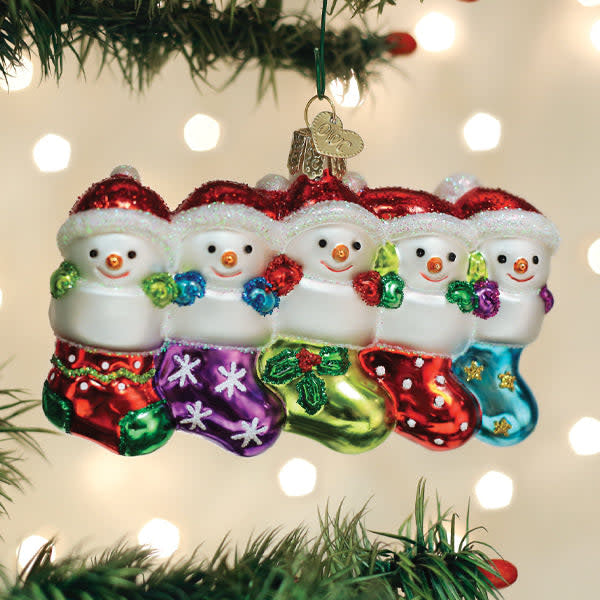 Snow Family Of 5 Ornament: white resin ornament with five stylized figures in winter coats and hats against a snowy background.