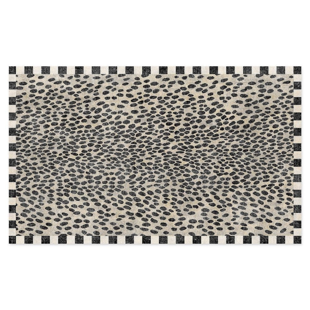 Small rectangular washable rug with snow leopard spots on a check border in woven polyester.
