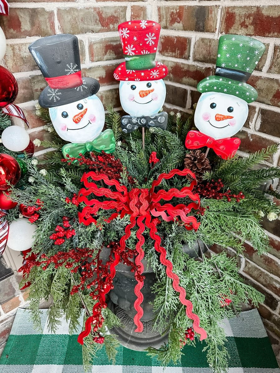 Snowball Snowmen stake decoration with white snowman figure on a natural wood stick.