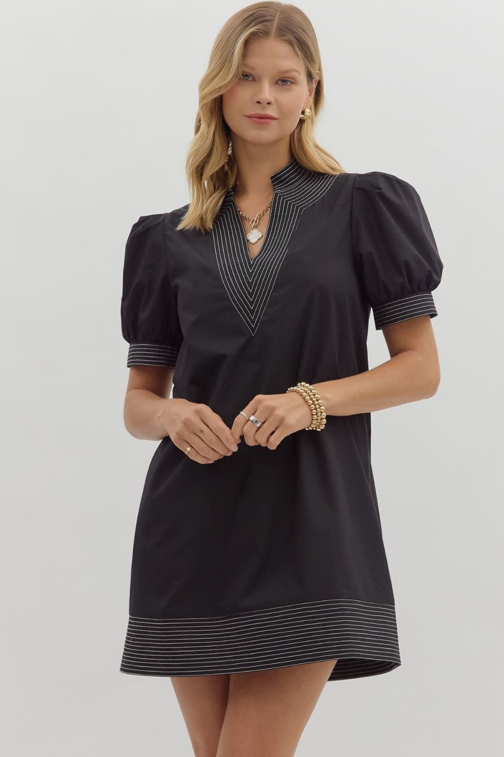 Solid mini dress with puff sleeves, contrast stitching at neckband and hem, side pockets.