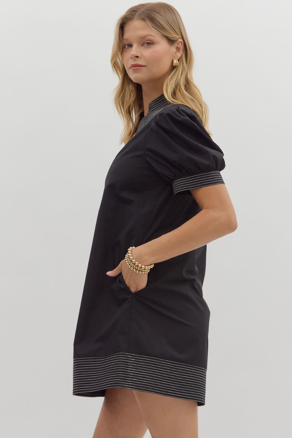 Solid mini dress with puff sleeves, contrast stitch neck band, side pockets, and hem finish.