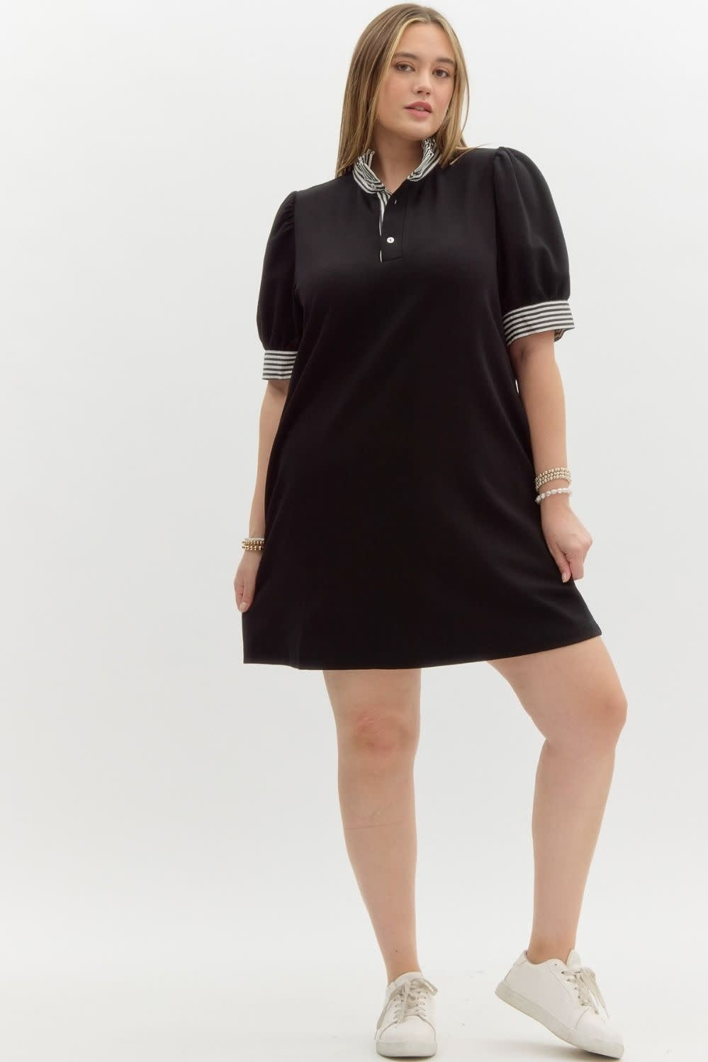 Black knit polo dress with short sleeves, ruffled neckline, side pockets, and a relaxed silhouette.