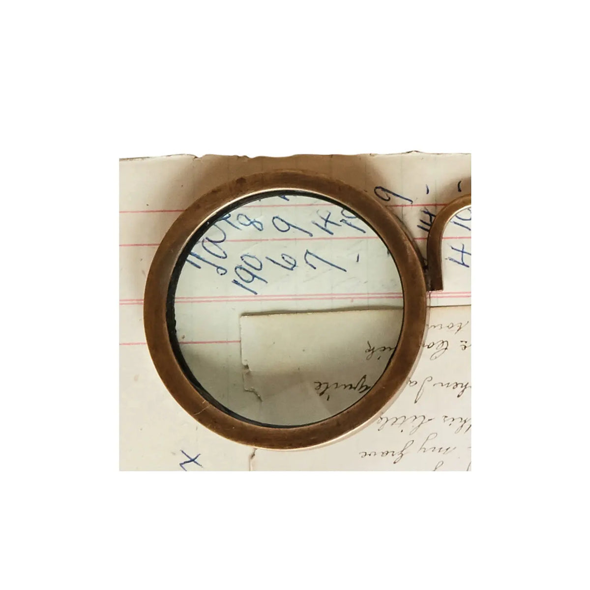 Antique-style magnifying spectacles with a circular lens on a decorative frame.