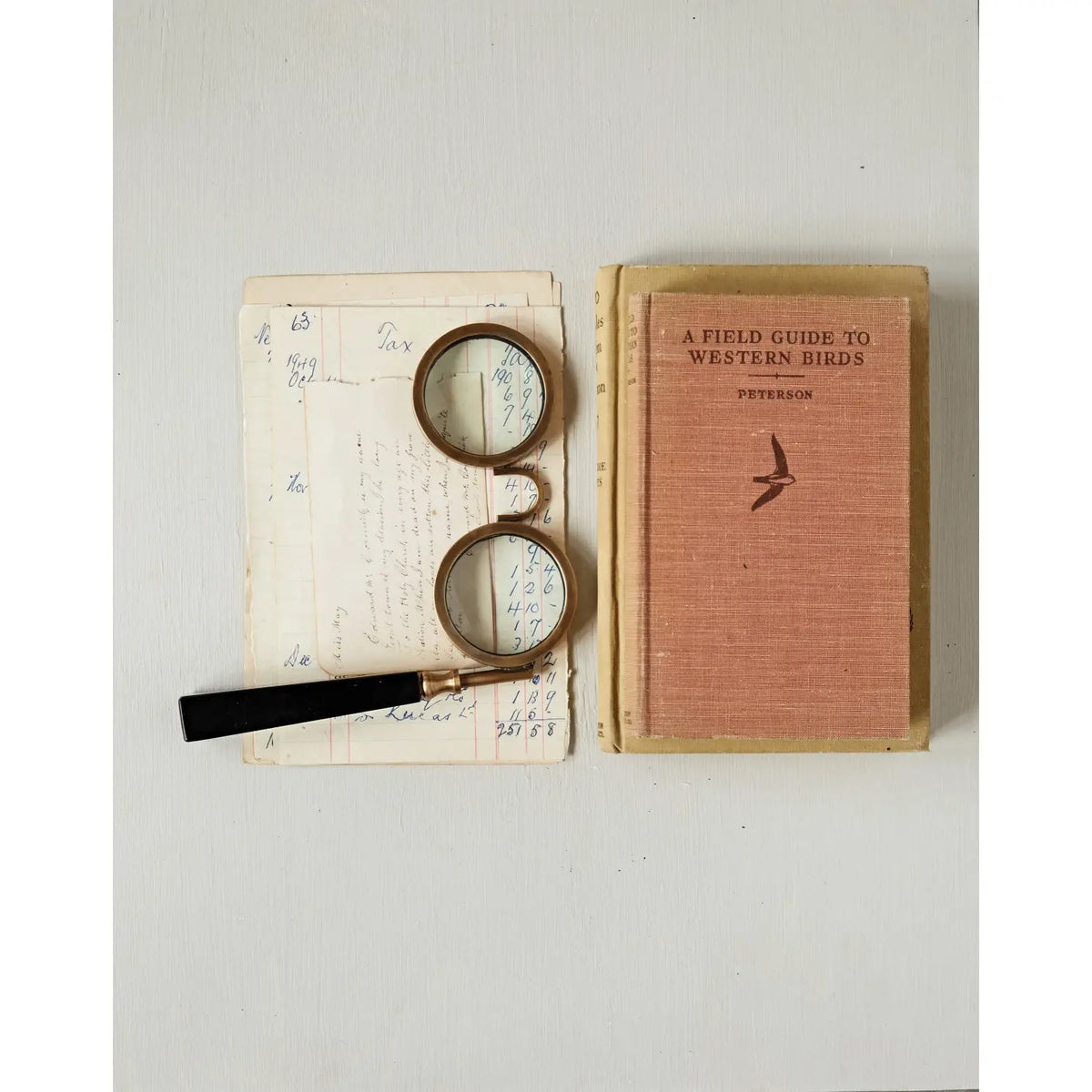 Antique-style magnifying glass spectacles with a circular lens on a decorative frame.