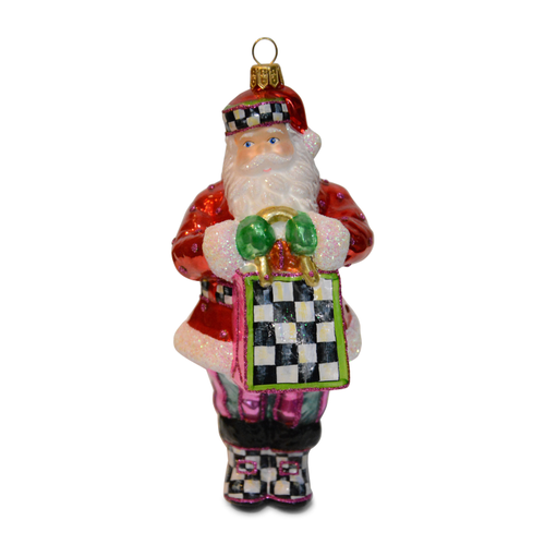 Shopper Santa glass ornament with a checkered hat, bag, and boots, holding green mittens.
