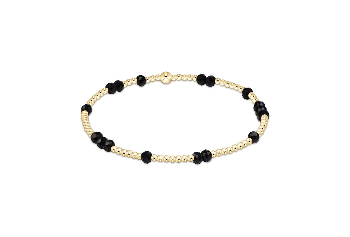 Gameday Flirty Hope Unwritten Bracelet with gold beads and faceted black stones.