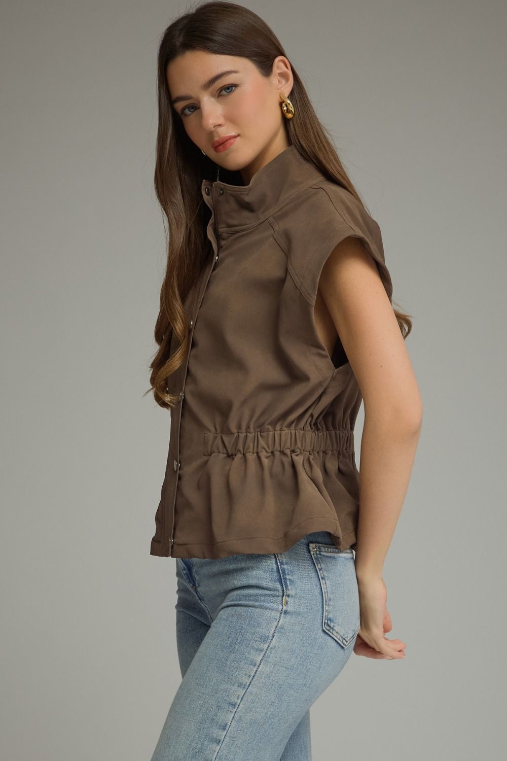 Woman wearing a Sarah Solid Cap Sleeve Jacket in brown with light wash jeans.
