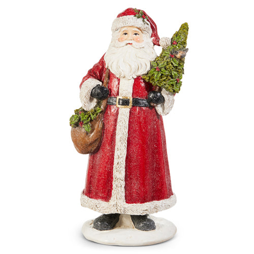 12.5-inch resin Santa figurine in a red coat holding a small tree and a brown sack.