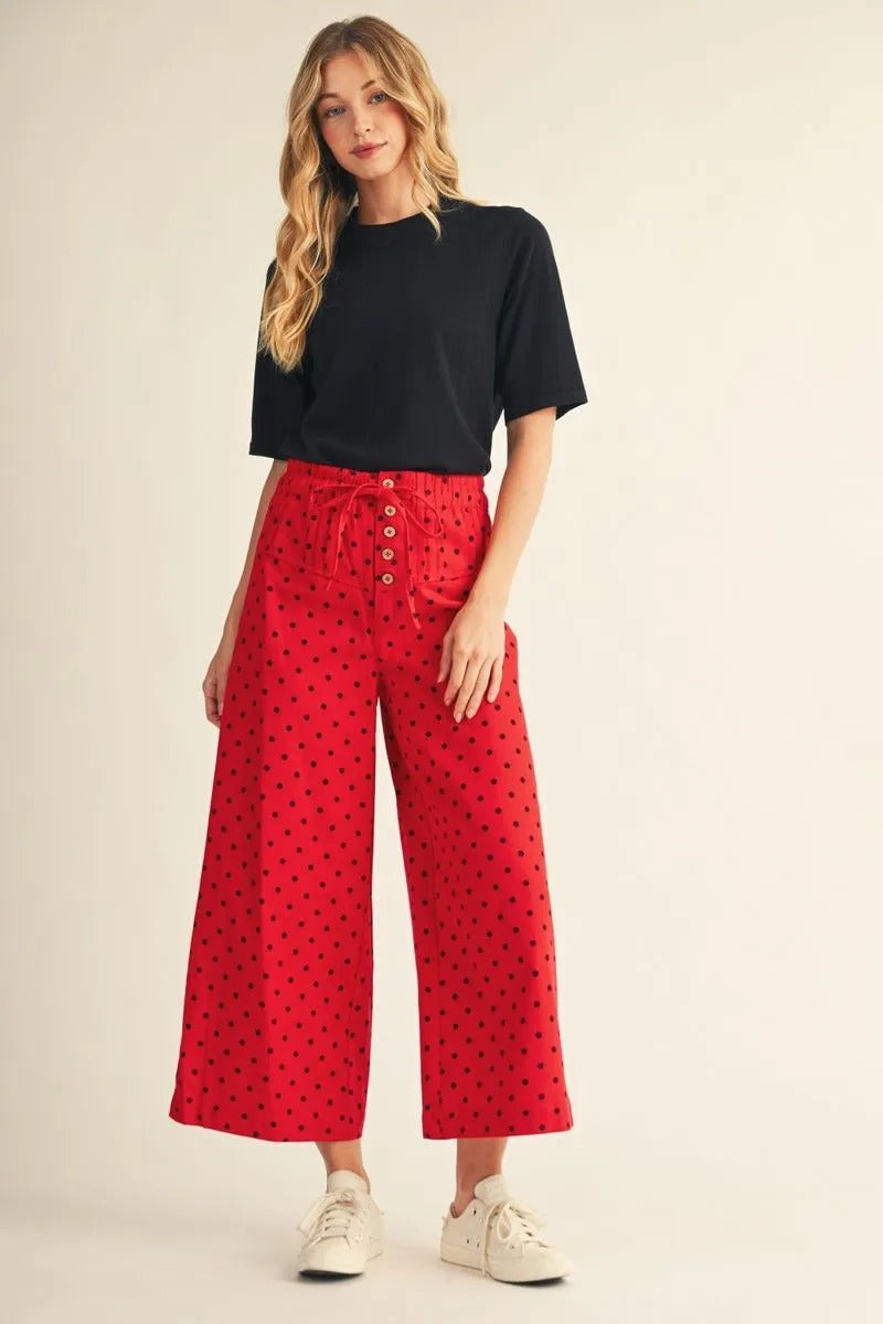 Woman wearing the Abigail black half-sleeve round neck sweater top with red polka dot pants.