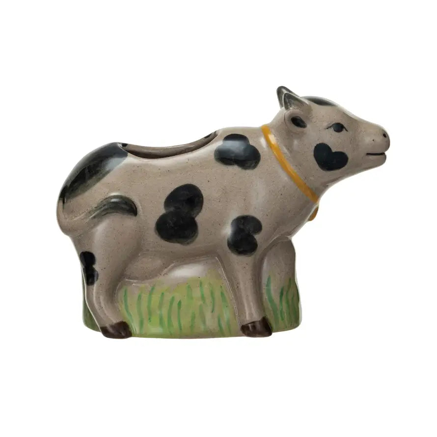 Stoneware cow vase with crackle glaze finish featuring a grass detail on its back.
