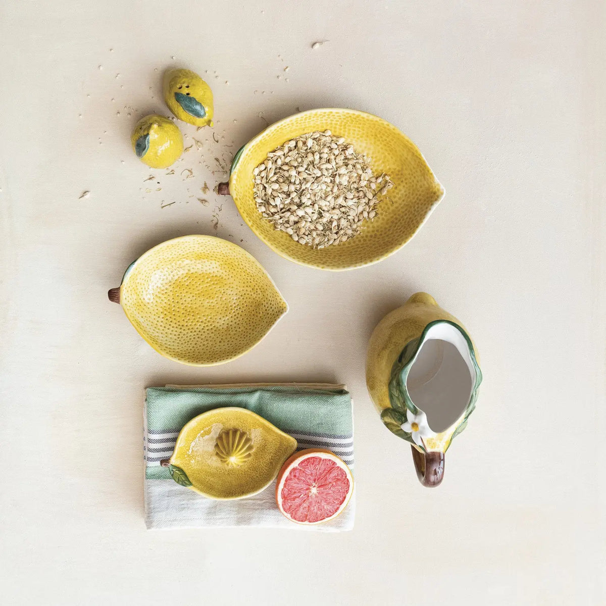 Stoneware lemon-shaped juicer in vibrant yellow with green accents