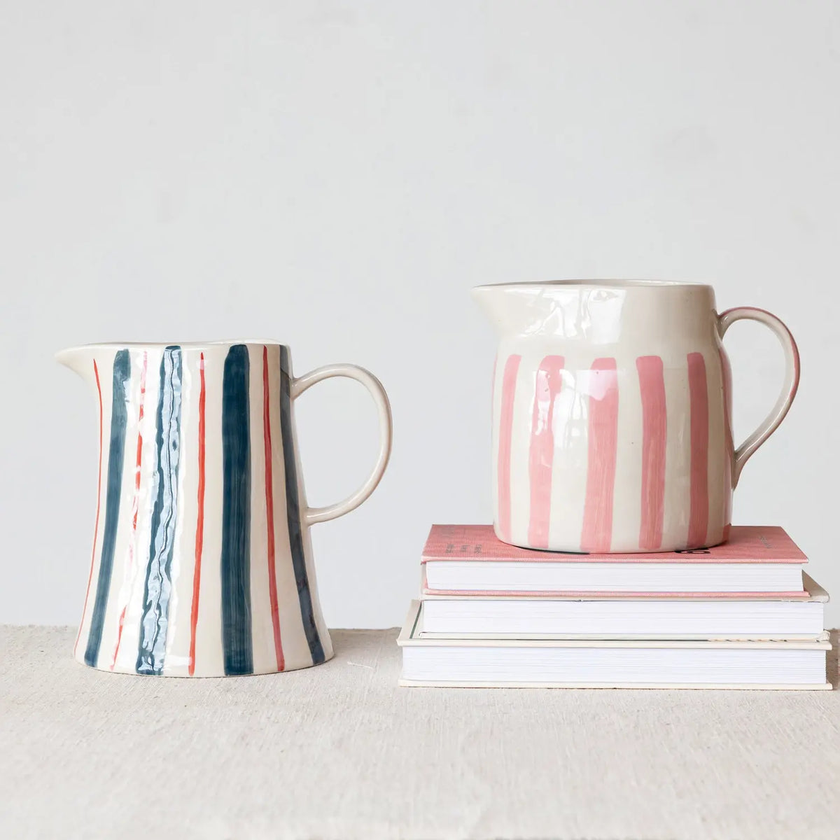 Pink hand-painted stoneware pitcher with wax relief stripes