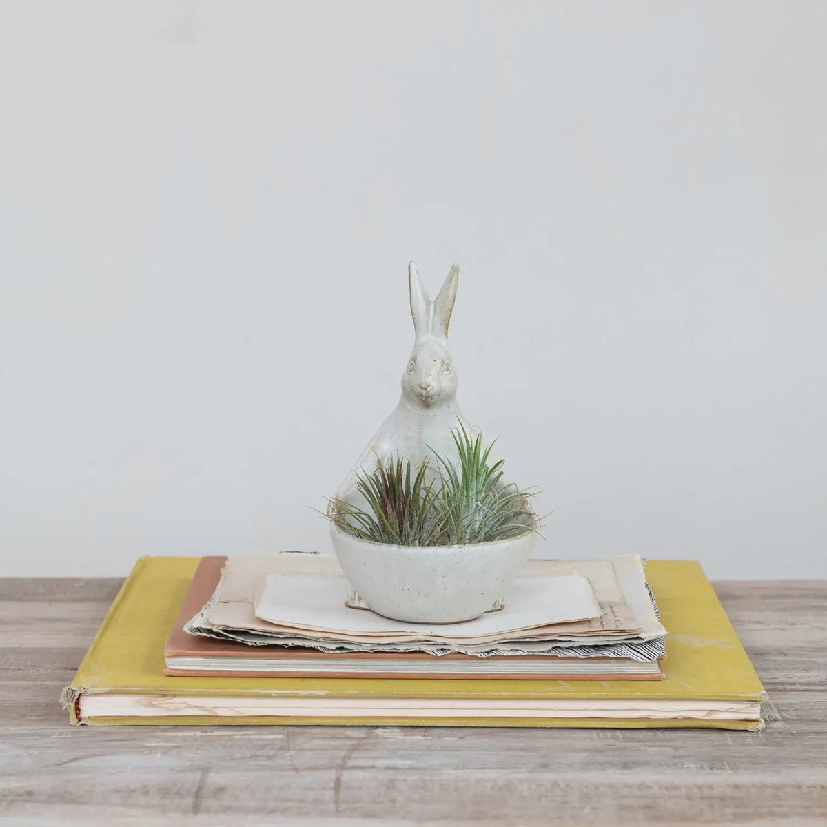 Stoneware rabbit planter with integrated bowl in off-white ceramic featuring whimsical silhouette and rustic texture.