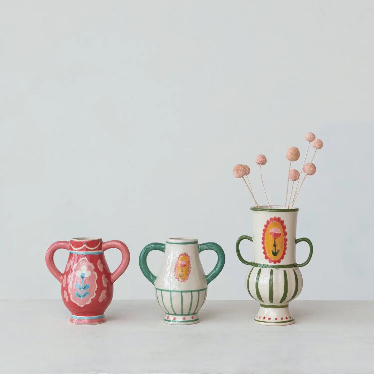 Hand-painted stoneware urn with floral motif, handles, cream base color.