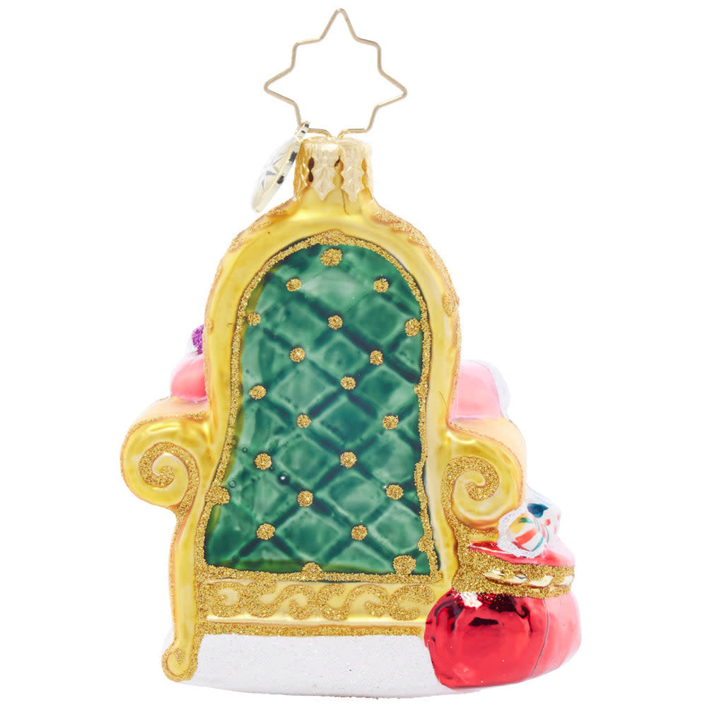 Small Santa figurine in red velvet with gold trim holding a scroll.