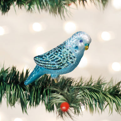 Blue miniature parakeet ornament with green wings on a gold stand