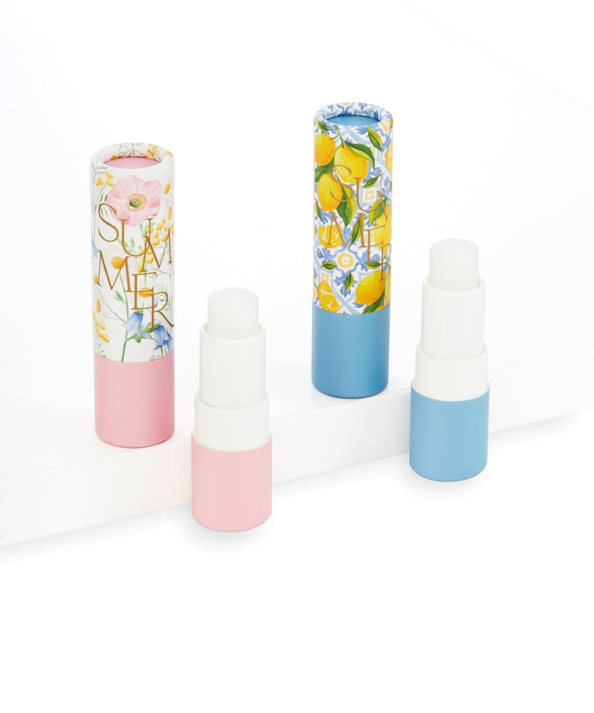 Small round tube of Summer Lip Balm in a light pink shade with white cap.