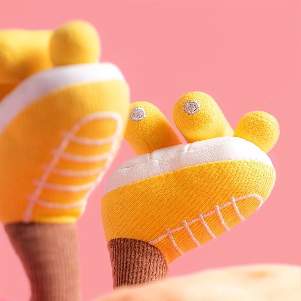 Close-up of yellow plush sun roller skates with white soles, pink laces, and brown legs.