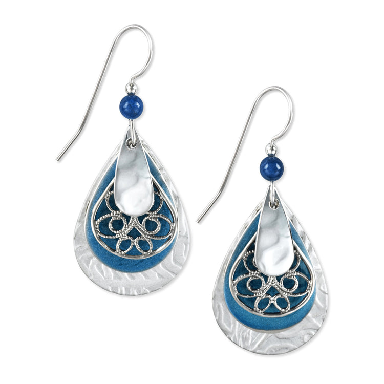 Layered surgical steel earrings with silver-blue teardrop filigree shapes featuring textured cutouts and glass bead accents.