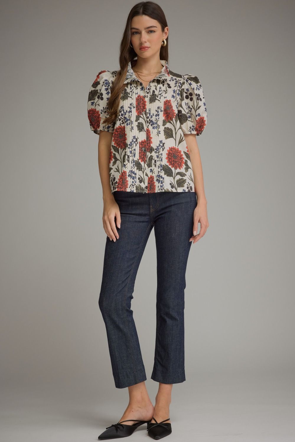 Woman wearing a white Amanda floral short puff sleeve top with pintuck details and dark wash jeans.