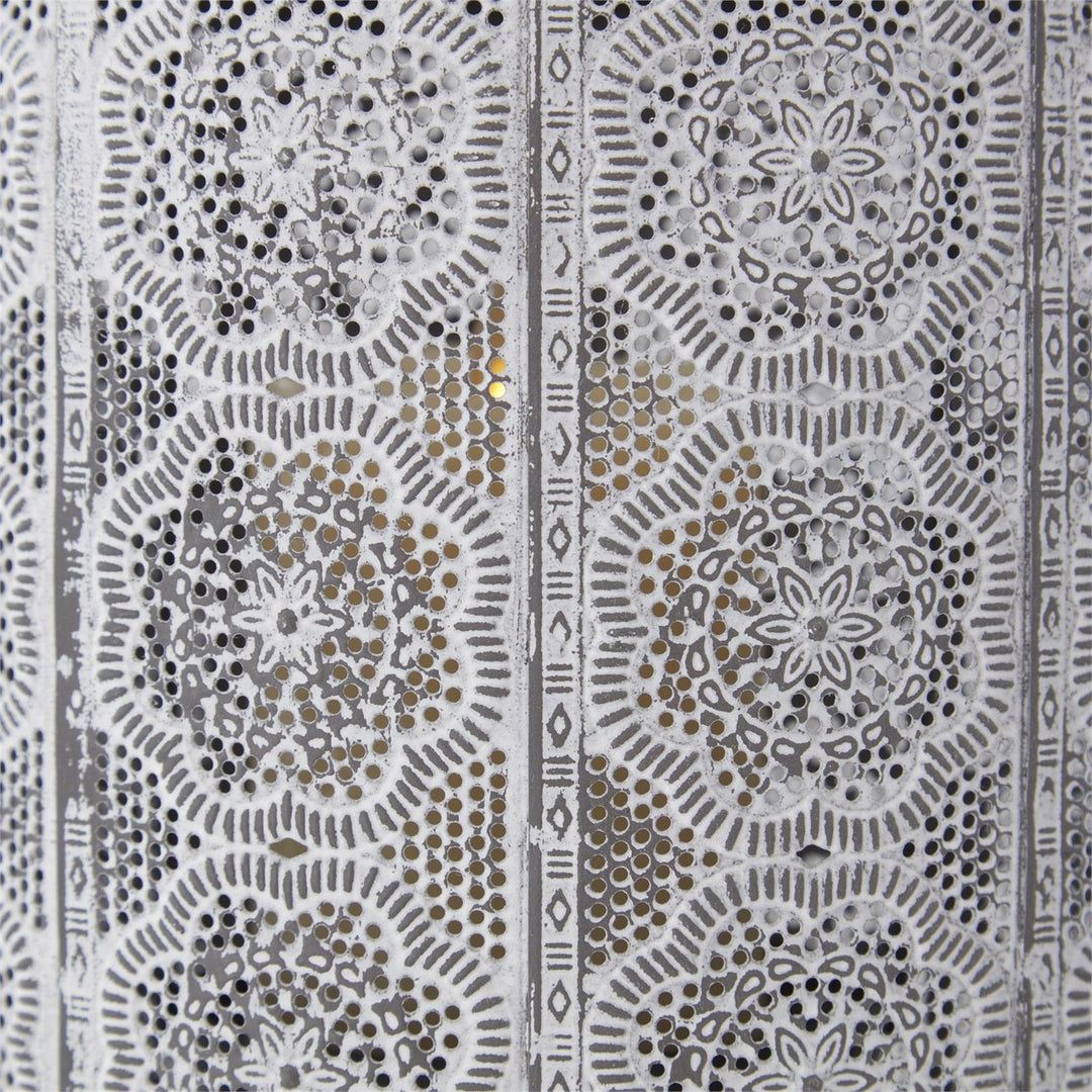 Close-up of whitewashed punched metal lantern featuring intricate floral medallion patterns.