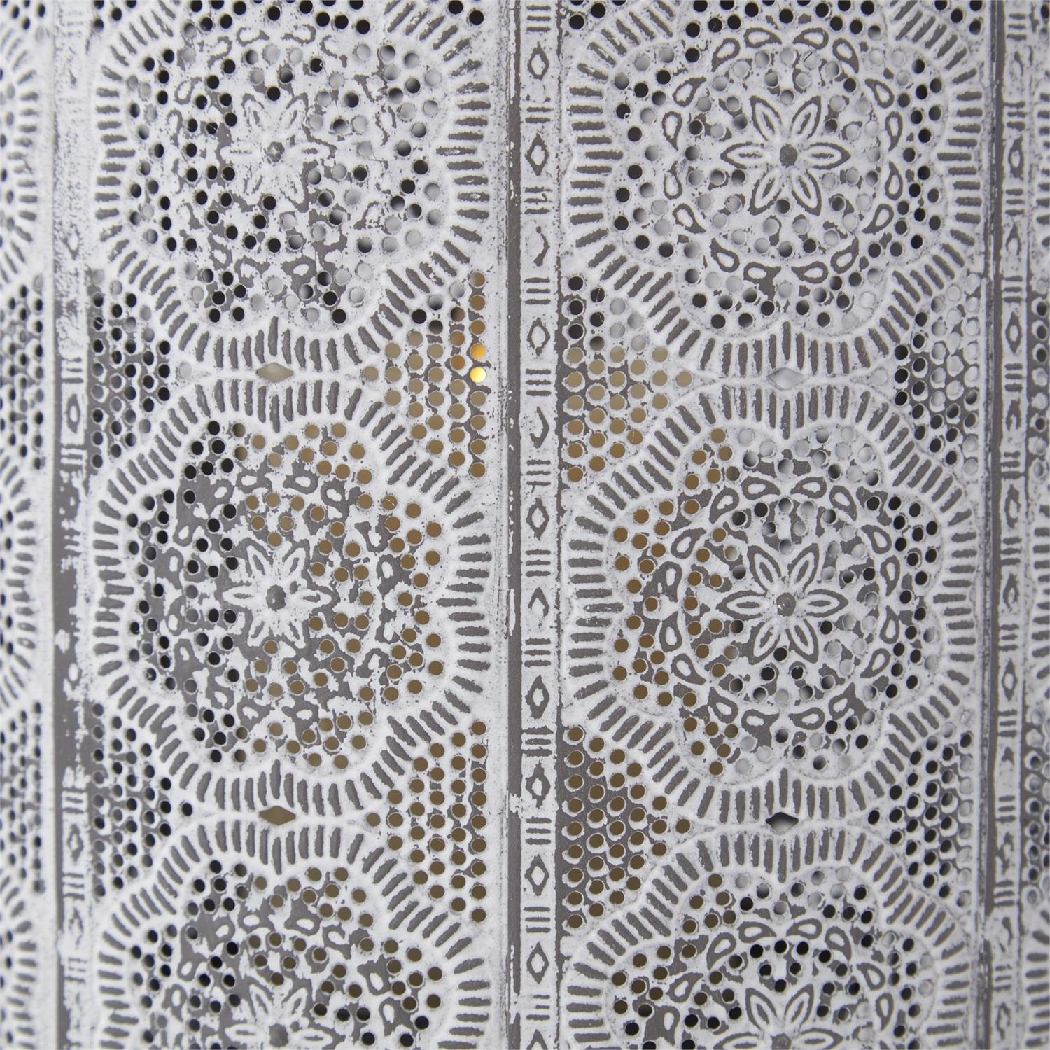 Close-up of whitewashed punched metal lantern featuring intricate floral medallion patterns.