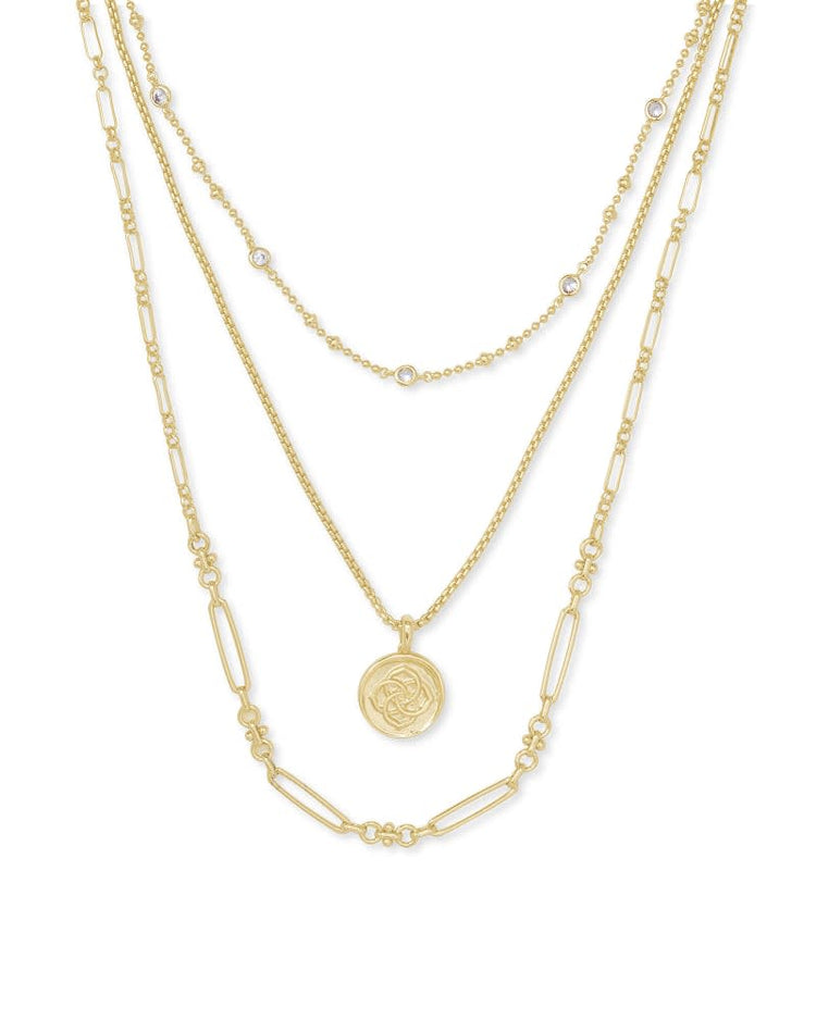 Gold triple strand necklace with a medallion coin pendant and crystal accents.
