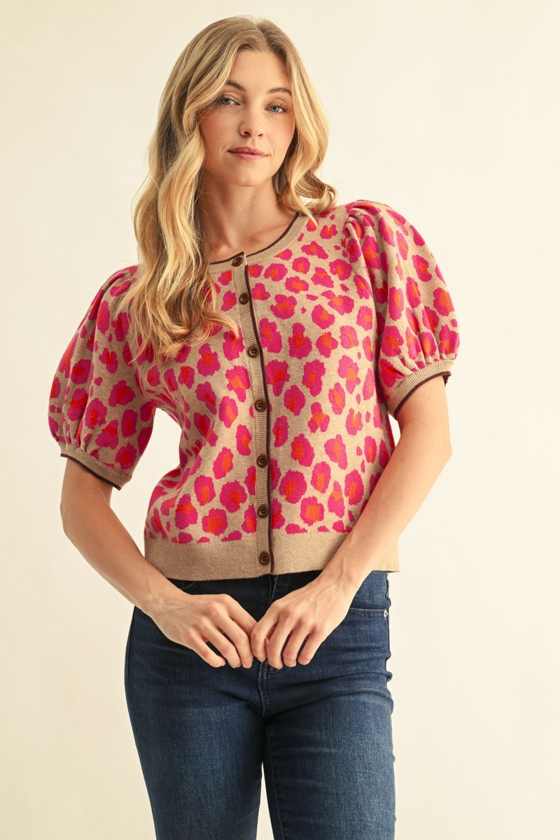 Woman wearing the Annie Leopard Sweater Cardigan with short puff sleeves and pink leopard print.