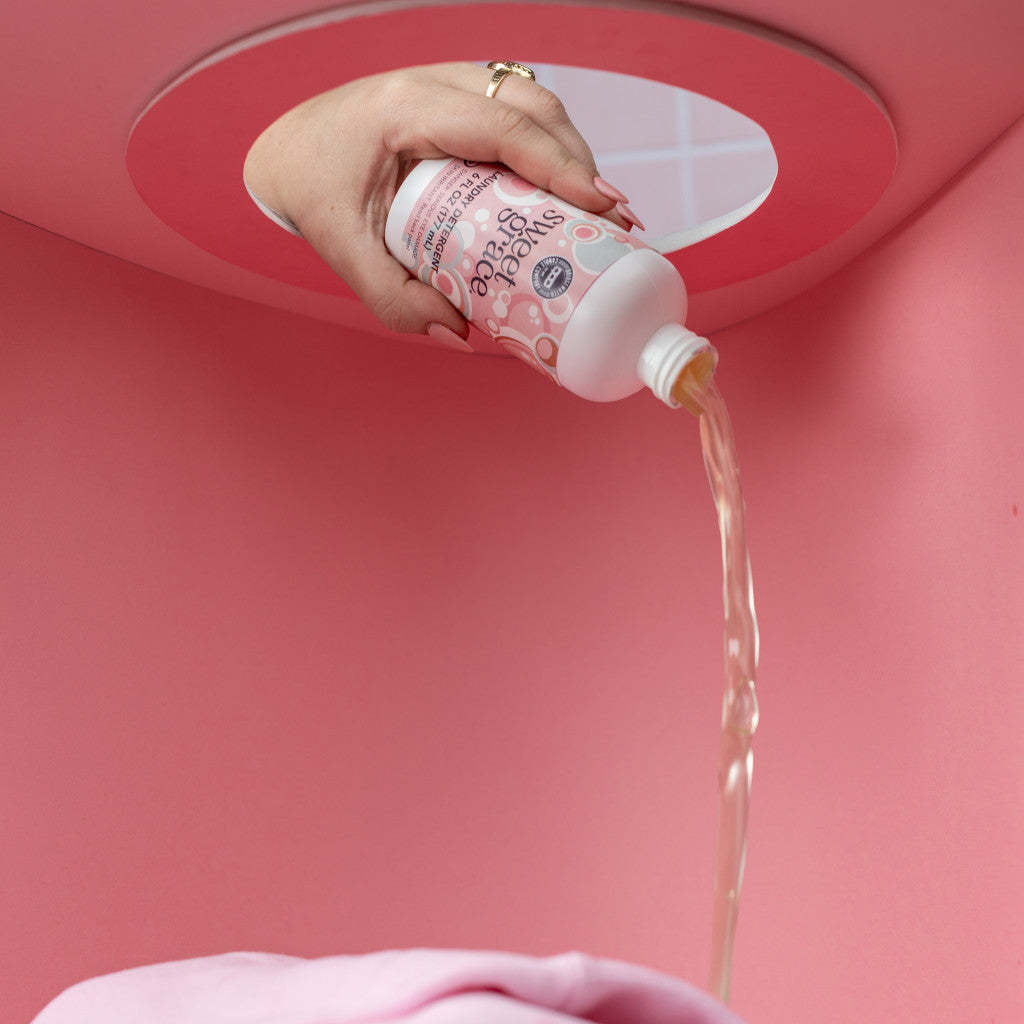 6 oz bottle of Sweet Grace laundry detergent with a white label featuring exotic passion fruit and patchouli scent notes.