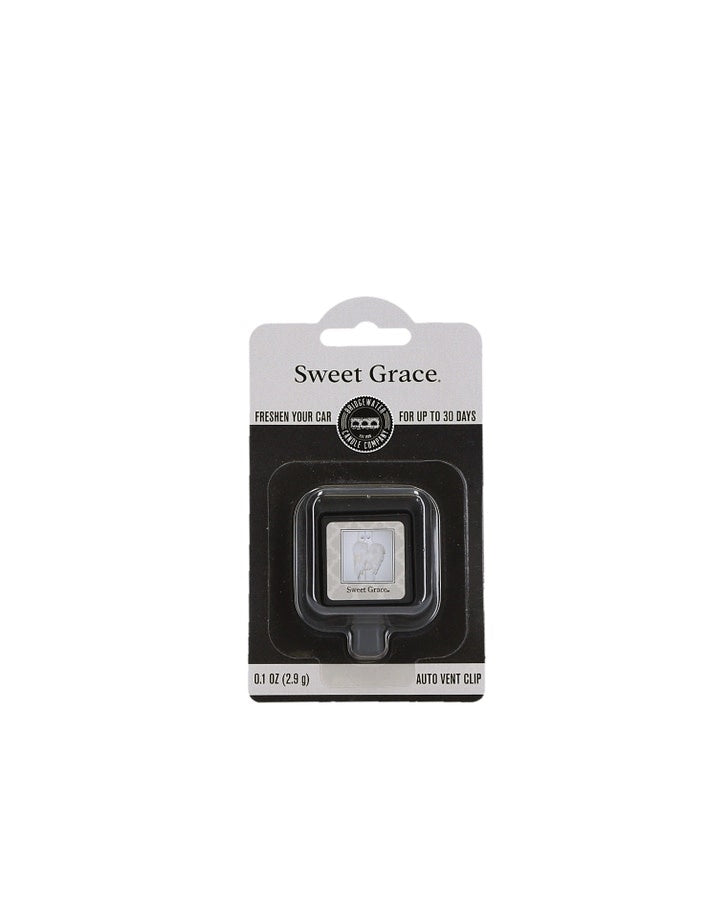 Sweet Grace Auto Vent Clip in black plastic with a silver dial attached to an air vent.