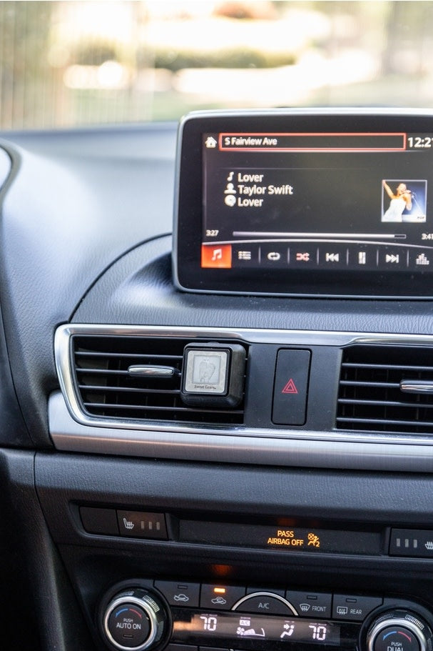 Sweet Grace Auto Vent Clip in silver metal with a black fragrance cartridge attached to an air vent.