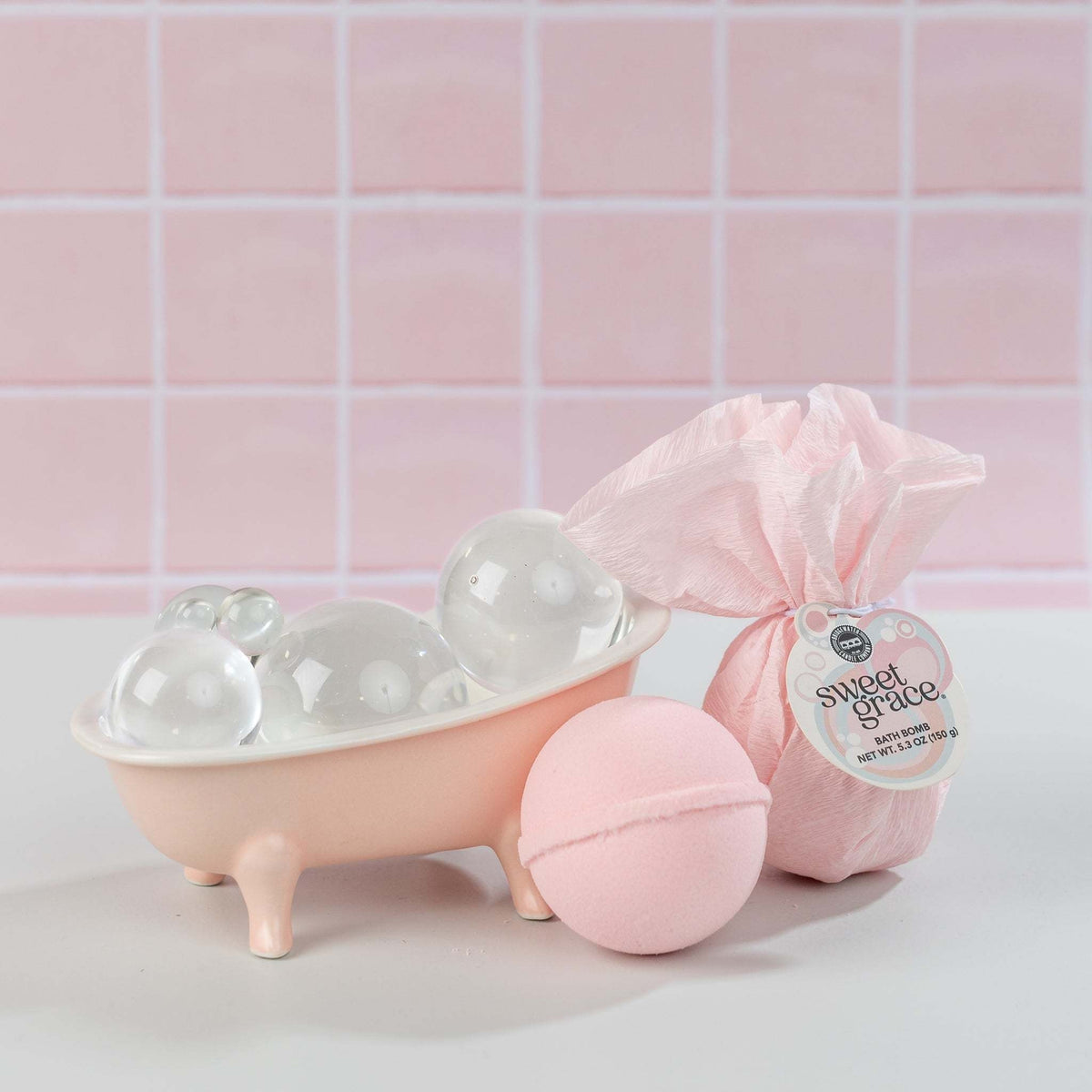 Round Sweet Grace bath bomb with pastel pink hue and fizzy texture