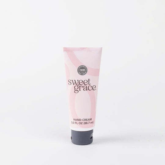 White tube of Sweet Grace hand cream with orange cap showing shea butter lotion.