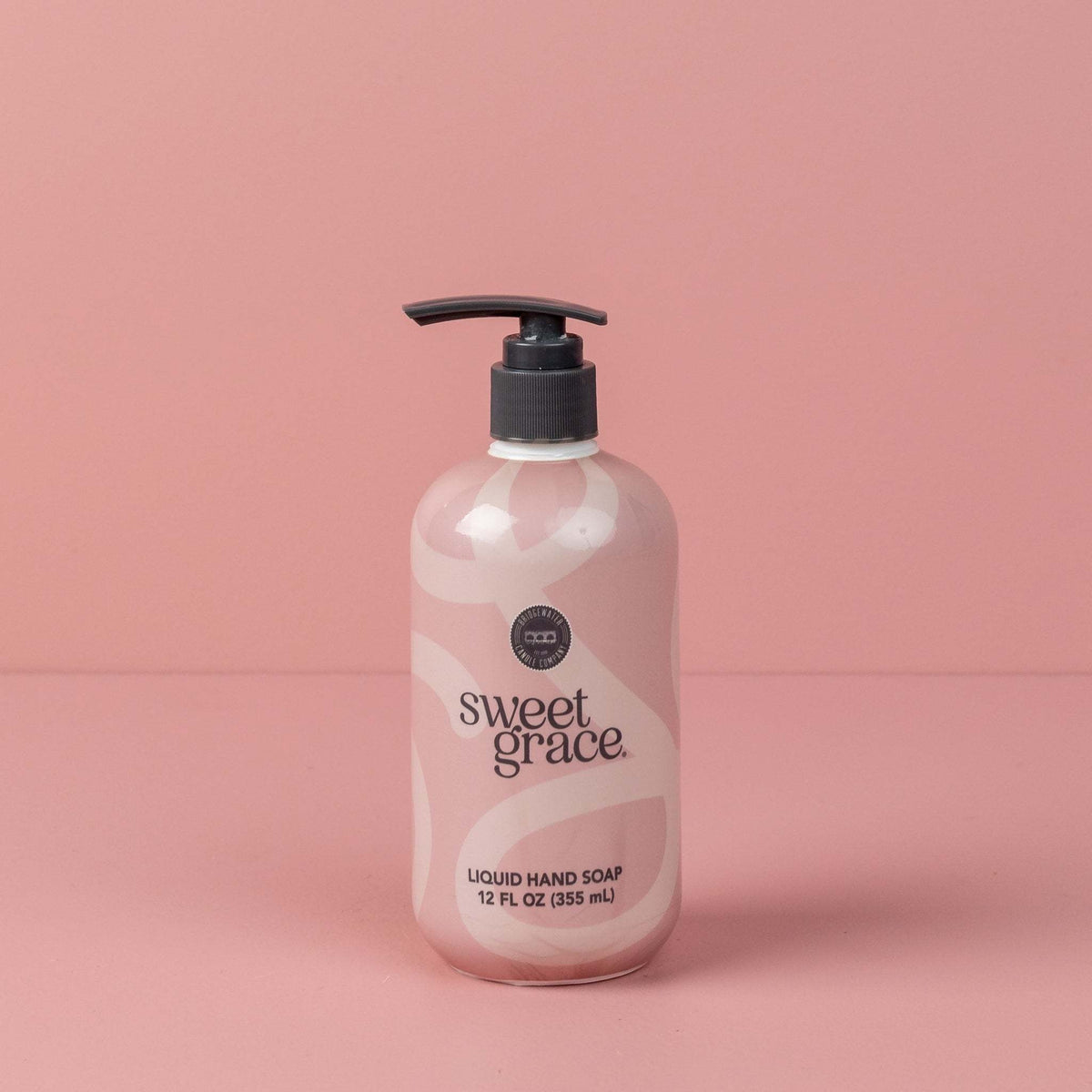 Pump bottle of Sweet Grace liquid hand soap with sweet grace fragrance in a clear container.
