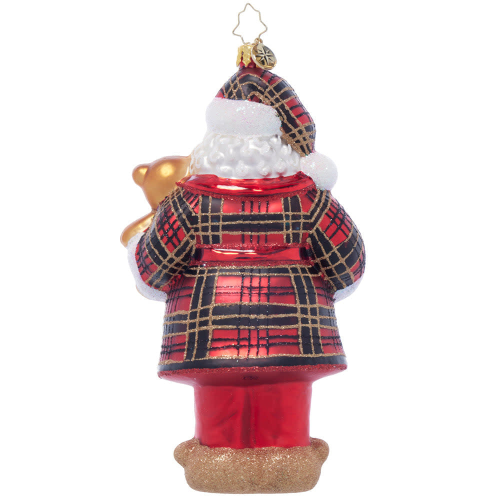 Santa figurine in plaid pajamas holding a treat with dimensions 7 inches high.