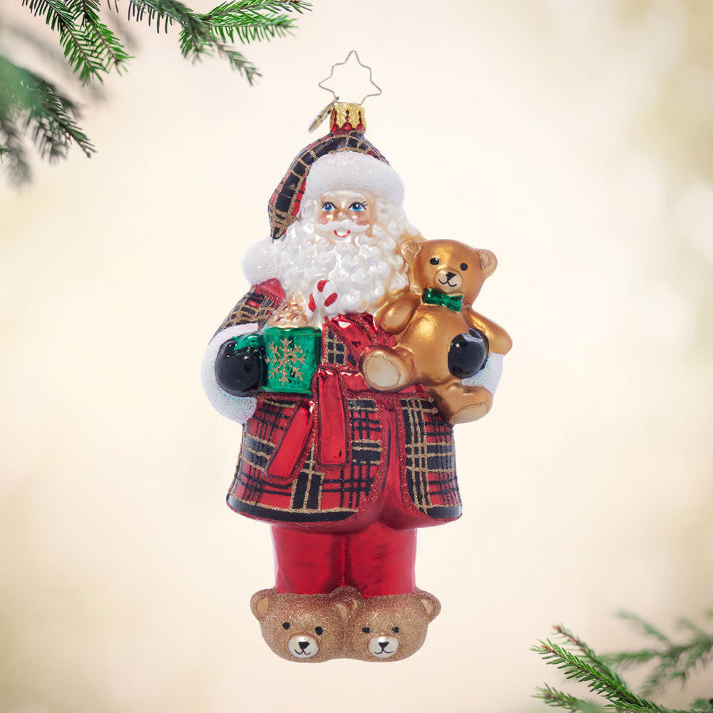Santa figurine in plaid pajamas holding treats with a smiling face.