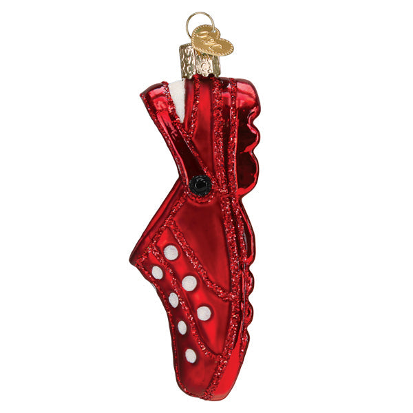 Red glittery rubber clog glass Christmas ornament with white polka dots and a gold heart charm.