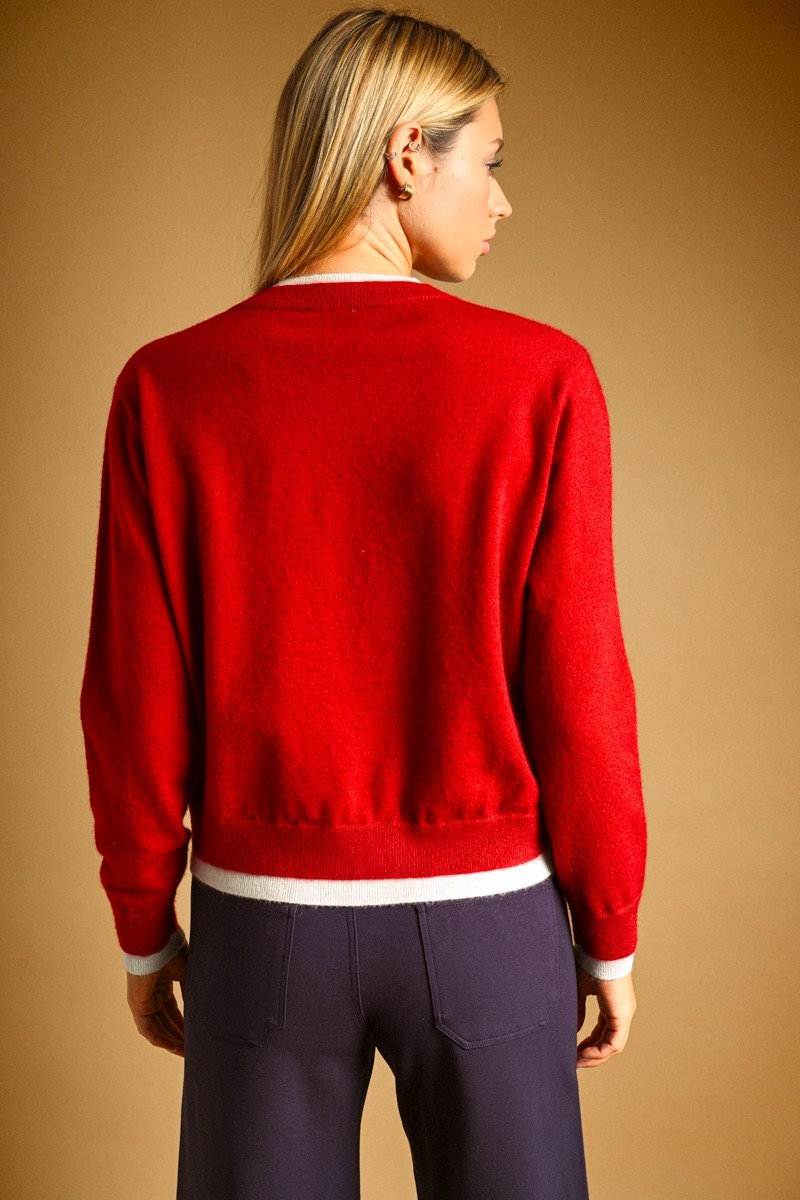 Back view of a red crew neck cardigan with white contrast trim at the hem and cuffs.