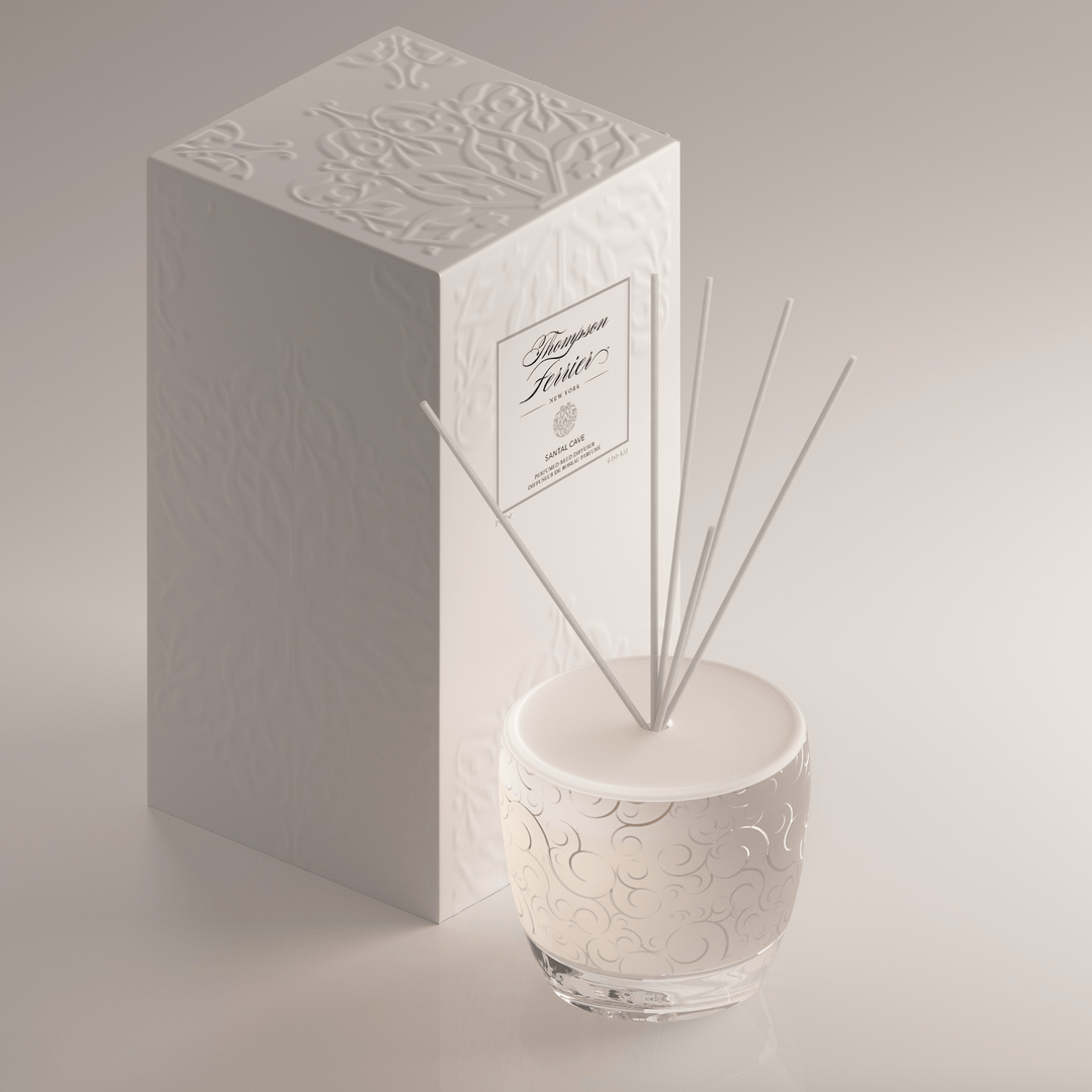 Santal Cave reed diffuser bottle with natural wood sticks in a neutral-toned glass container.