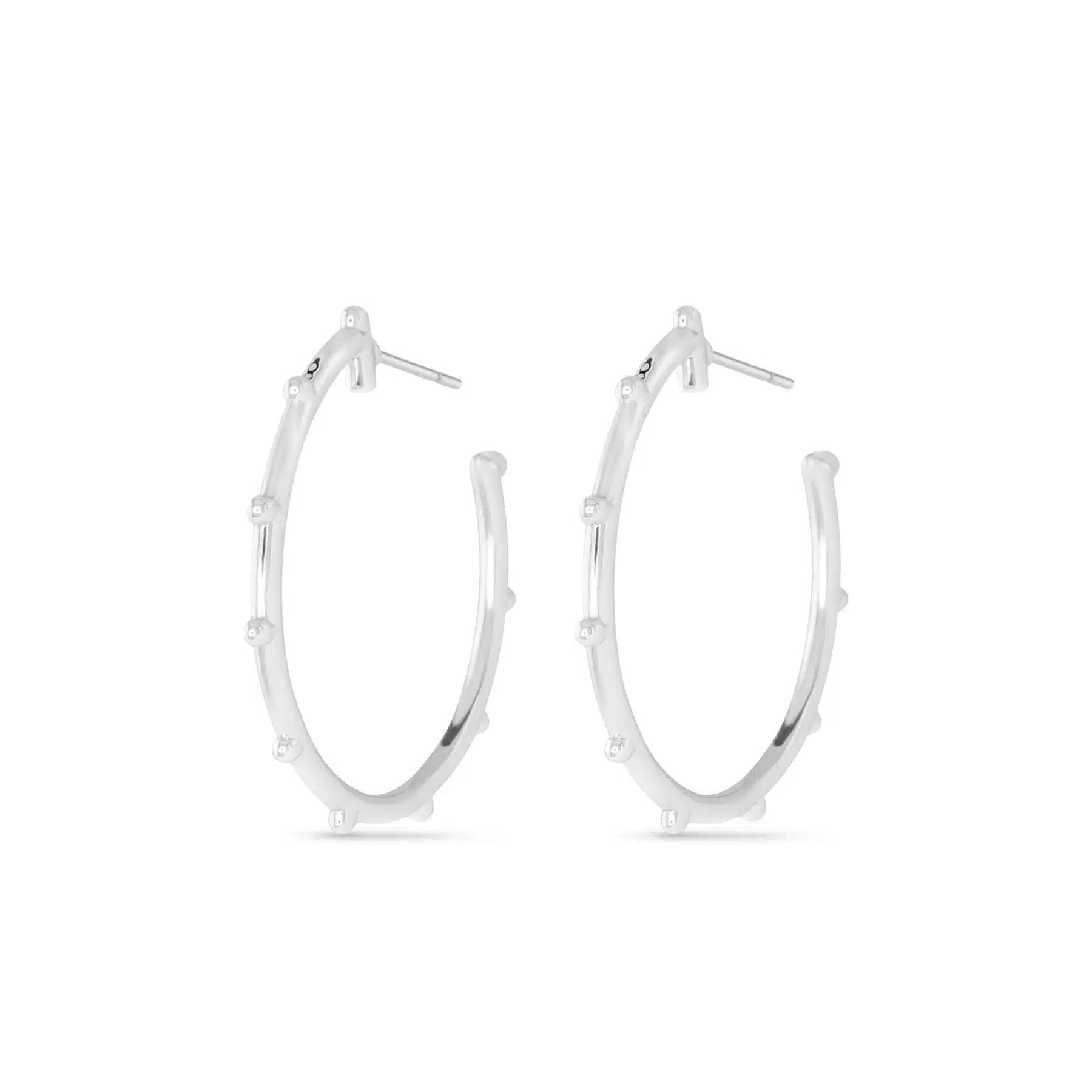 Pair of silver Dorthy hoop earrings with small decorative studs along the outer edge.
