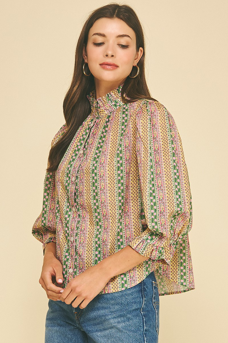 Woman wearing the Mabel Floral Botanical Print Button Down Blouse with a ruffled high neck.