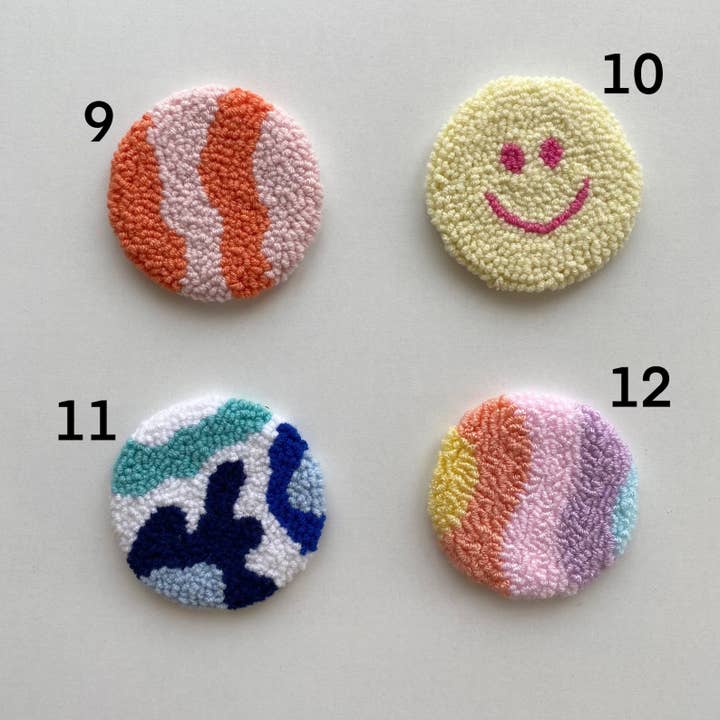 Four colorful punch needle car coasters with wavy patterns and a smiley face, numbered 9 to 12.
