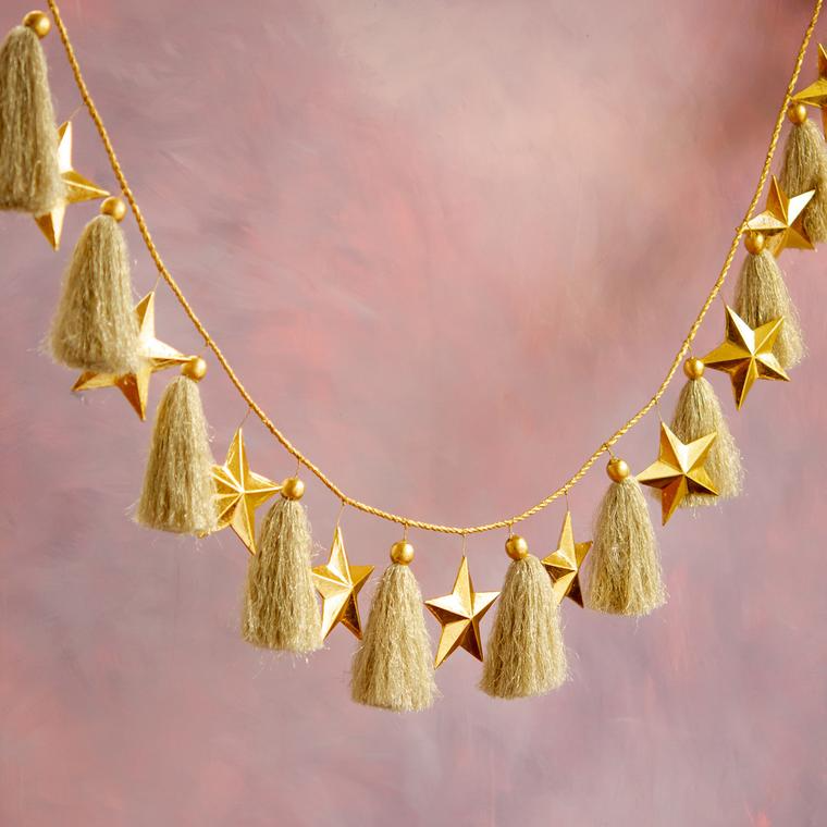 Gold star garland with alternating metallic gold stars and beige tassels on a gold cord.
