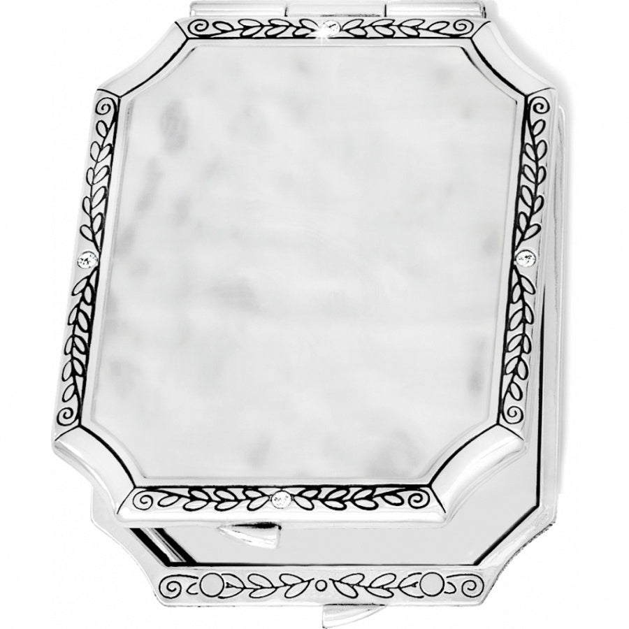 Silver plated compact tapestry with French clip closure and one side offering 2.5 magnification.