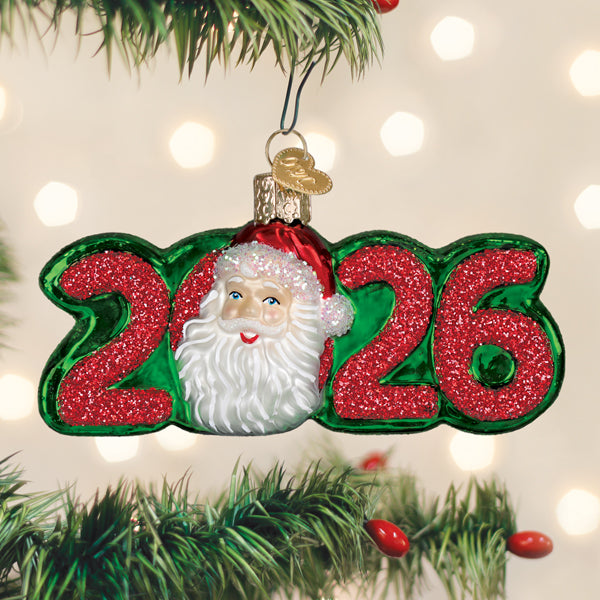 Red glass Santa ornament with white beard and black hat hanging from a gold loop.