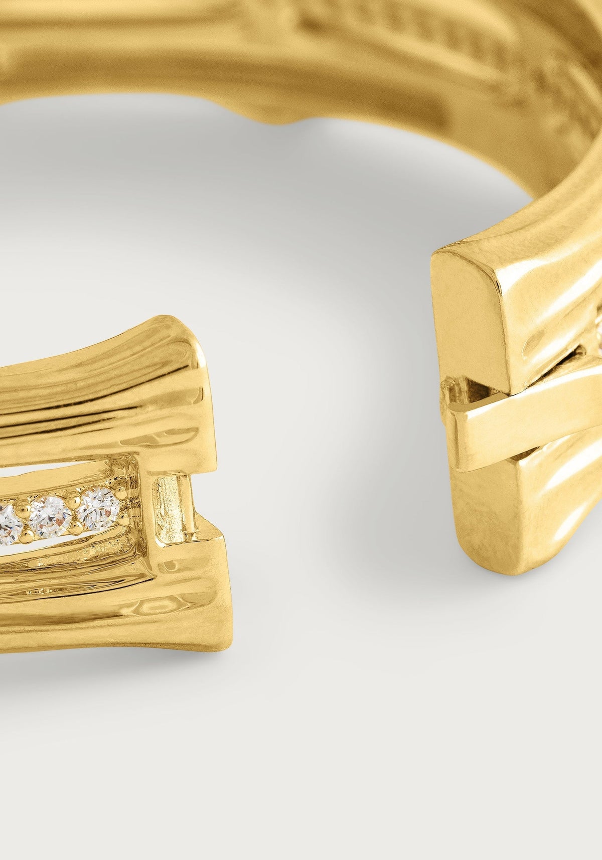 Close-up of a gold-plated bamboo stacked hinged bangle with crystal pavé and a hidden clasp.