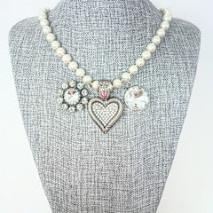 Fashion pearl necklace with three charms ranging from one to one-and-a-half inches featuring an intricate bail on the heart charm