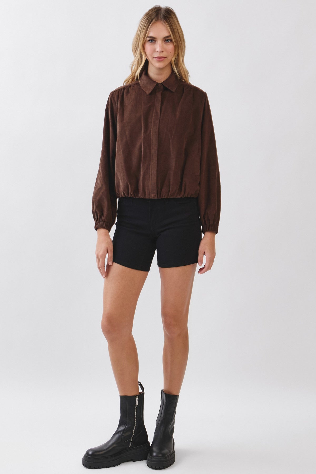 Woman wearing a brown Julie Corduroy Zip-up Collar Jacket with black shorts and black boots.