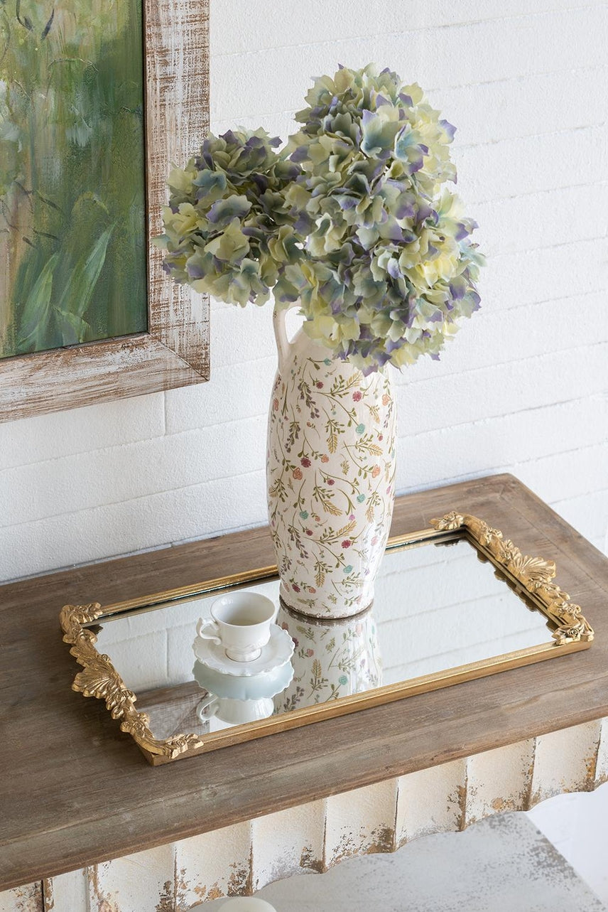 Gold-framed mirror tray featuring an intricate floral cutout pattern.