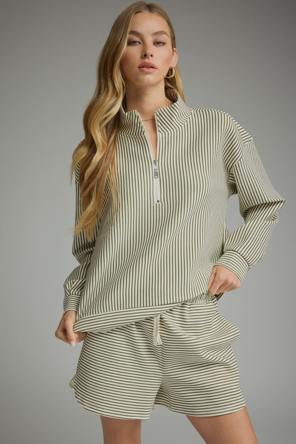 Woman wearing the Melissa Stripe Long Sleeve Knit Top with a quarter zipper and matching shorts.
